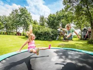 Spaß für Groß und Klein auf dem großen Trampolin im Garten