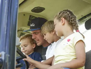 Kinder haben die Möglichkeit, mit dem Bauern auf dem Traktor mitzufahren