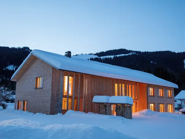 Holzhaus mit Ferienwohnungen beleuchtet im Schnee am Erlenhof in Bad Hindelang