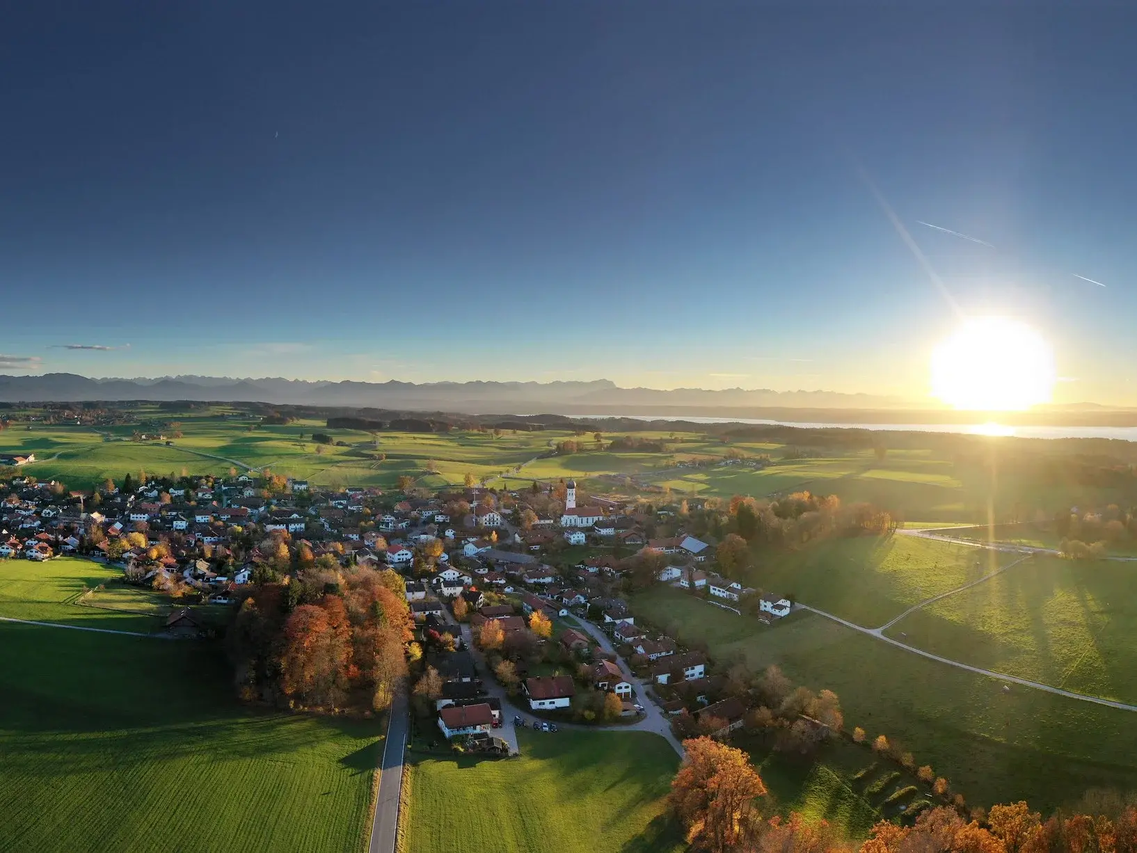 Panorama von Münsing - © Tölzer Land Tourismus, Jan Greune Panorama Luftbild des Ortes Münsing bei Sonnenschein