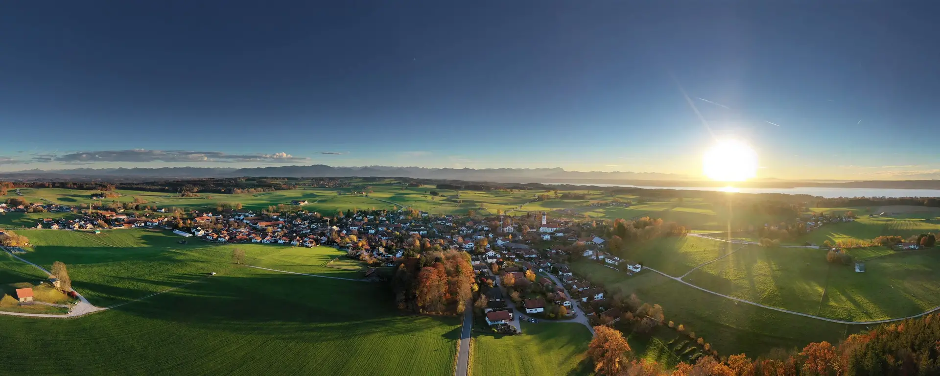 Panorama von Münsing - © Tölzer Land Tourismus, Jan Greune Panorama Luftbild des Ortes Münsing bei Sonnenschein