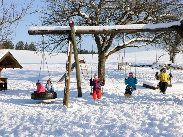 Spielplatz auf dem Bauernhof im Winter in der Region Chiemsee